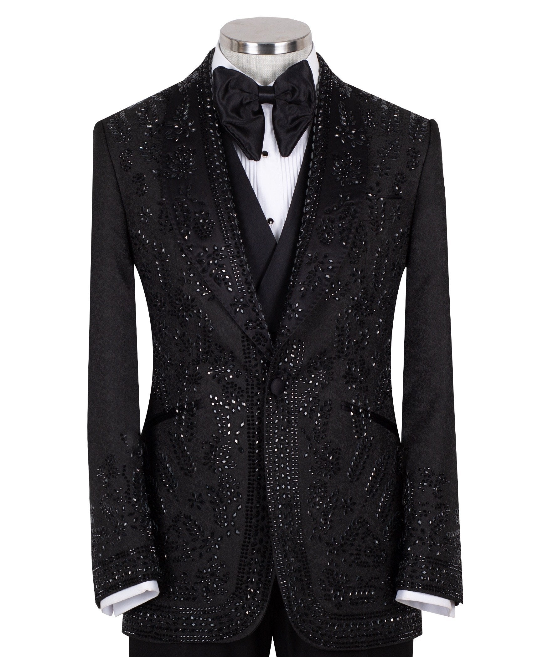 Front view of a black hand-embellished tuxedo with intricate beadwork and sequin patterns, displayed on a mannequin. Features a single-breasted jacket, peak lapel, matching vest, and trousers, embodying luxury bespoke craftsmanship from Istanbul.