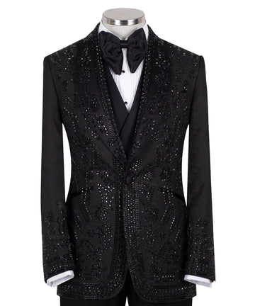 Front view of a black hand-embellished tuxedo with intricate beadwork and sequin patterns, displayed on a mannequin. Features a single-breasted jacket, peak lapel, matching vest, and trousers, embodying luxury bespoke craftsmanship from Istanbul.