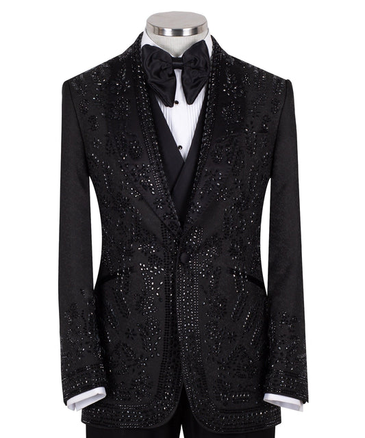 Front view of a black hand-embellished tuxedo with intricate beadwork and sequin patterns, displayed on a mannequin. Features a single-breasted jacket, peak lapel, matching vest, and trousers, embodying luxury bespoke craftsmanship from Istanbul.