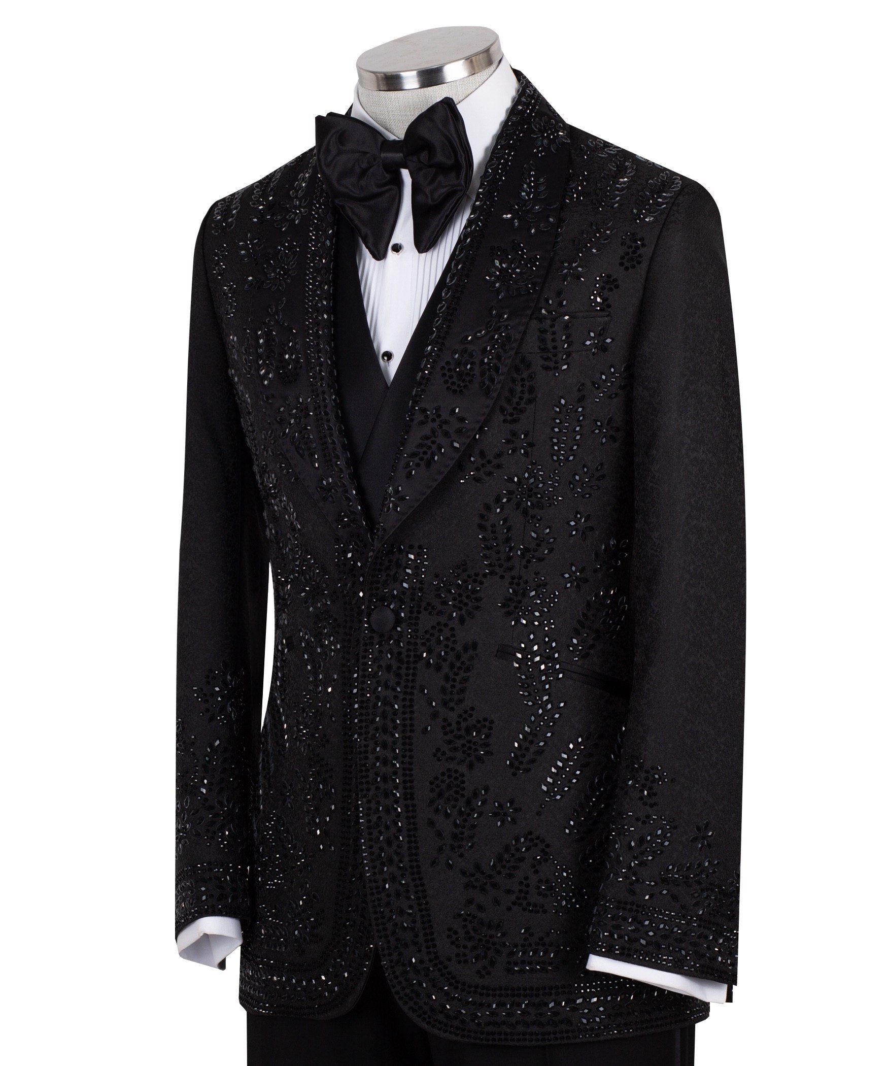 Front view of a black hand-embellished tuxedo with intricate beadwork and sequin patterns, displayed on a mannequin. Features a single-breasted jacket, peak lapel, matching vest, and trousers, embodying luxury bespoke craftsmanship from Istanbul.