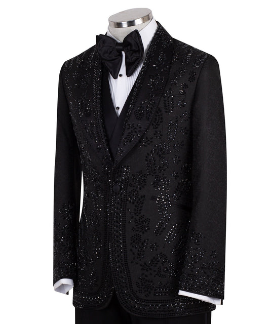 Front view of a black hand-embellished tuxedo with intricate beadwork and sequin patterns, displayed on a mannequin. Features a single-breasted jacket, peak lapel, matching vest, and trousers, embodying luxury bespoke craftsmanship from Istanbul.