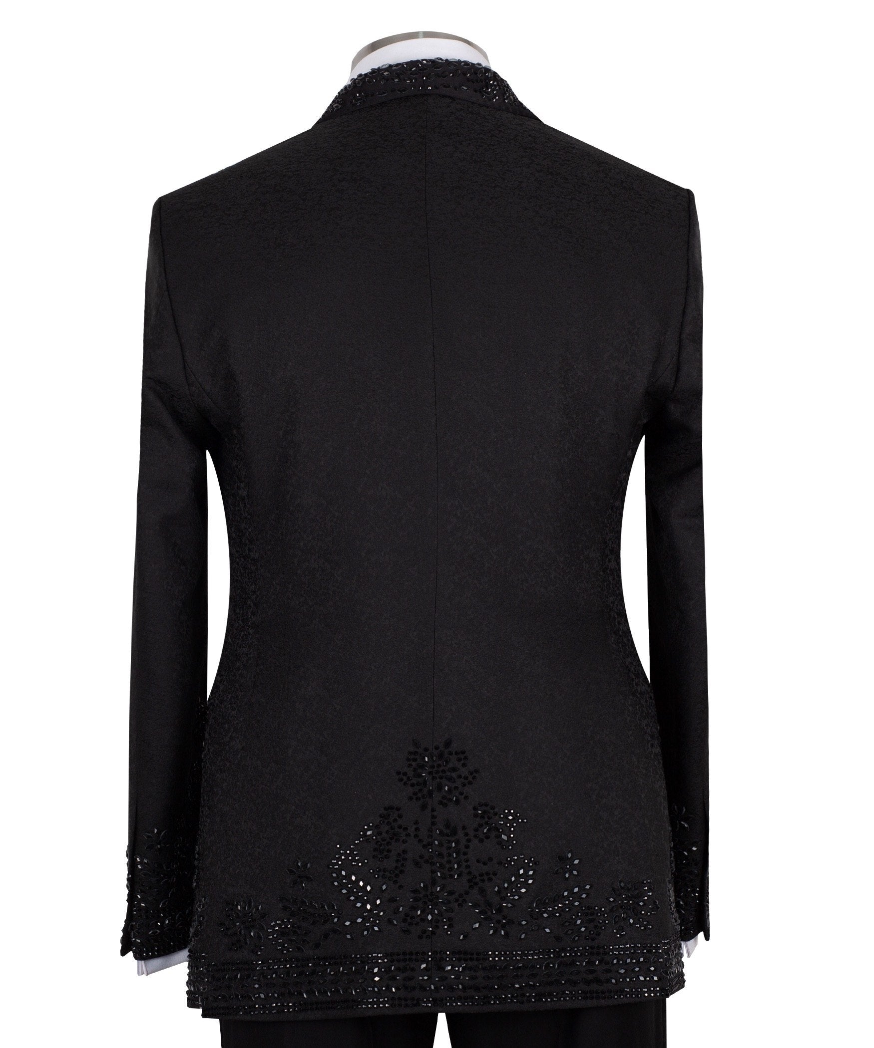 Front view of a black hand-embellished tuxedo with intricate beadwork and sequin patterns, displayed on a mannequin. Features a single-breasted jacket, peak lapel, matching vest, and trousers, embodying luxury bespoke craftsmanship from Istanbul.