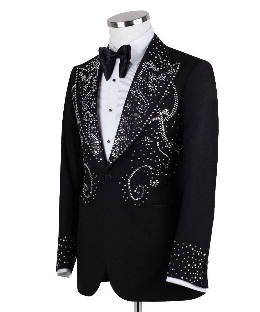 Black embellished three-piece tuxedo with intricate crystal and bead patterns on satin peak lapels, chest, and cuffs. Features a matching vest. Handcrafted luxury suit from Charly Luxury Istanbul.