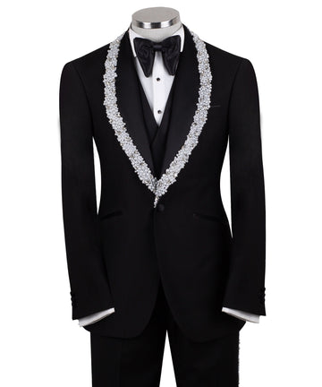 Full front view of a black three-piece tuxedo on a mannequin, featuring heavily hand-embellished shawl lapels with pearls and crystals, and a matching embellishment down the side of the trousers. Includes a black double-breasted vest and a white shirt with a black bow tie (not included).