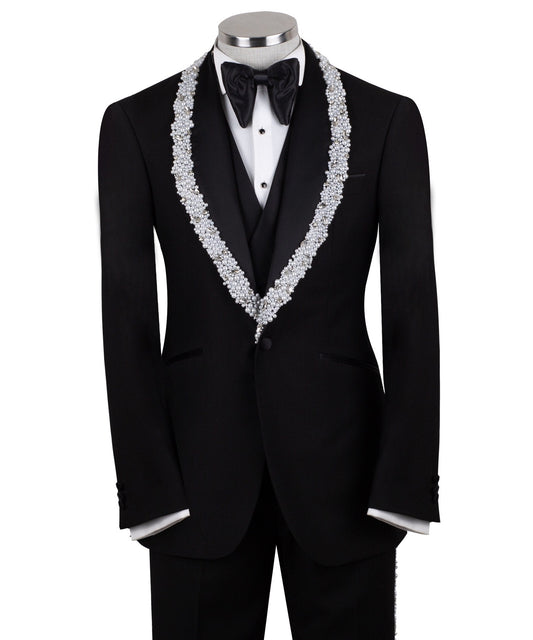 Full front view of a black three-piece tuxedo on a mannequin, featuring heavily hand-embellished shawl lapels with pearls and crystals, and a matching embellishment down the side of the trousers. Includes a black double-breasted vest and a white shirt with a black bow tie (not included).