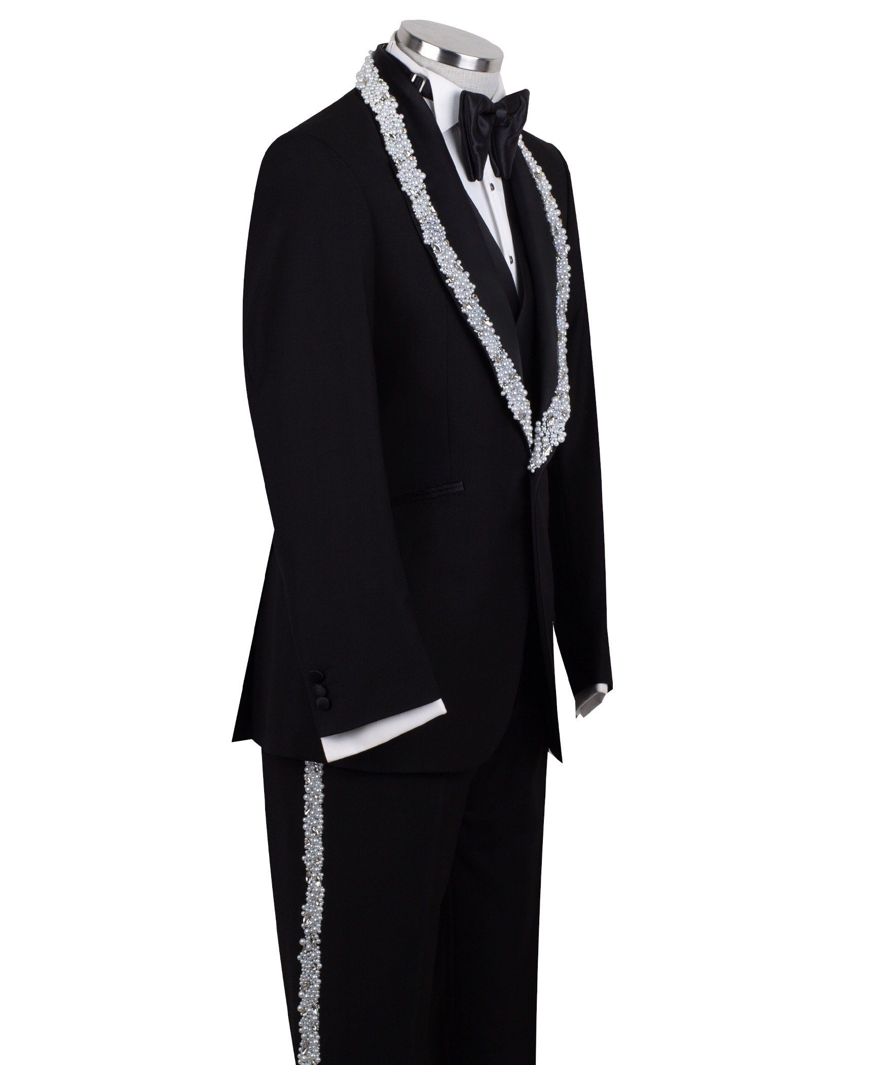 Full front view of a black three-piece tuxedo on a mannequin, featuring heavily hand-embellished shawl lapels with pearls and crystals, and a matching embellishment down the side of the trousers. Includes a black double-breasted vest and a white shirt with a black bow tie (not included).