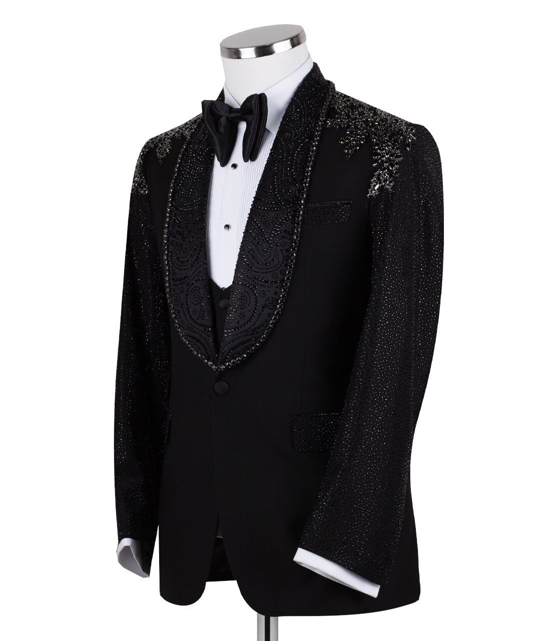 Black three-piece tuxedo on a mannequin, featuring a heavily hand-embellished shawl lapel, shoulders, and sleeves with intricate sparkling beadwork. The tuxedo includes a matching black vest and trousers, designed in a slim fit style, showcasing luxurious craftsmanship from Istanbul.