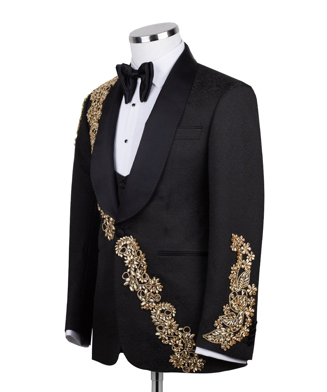 Front view of a black jacquard three-piece tuxedo with intricate gold hand-embellishments on the shawl lapel, shoulder, and cuffs, displayed on a mannequin. From Charly Luxury, handcrafted in Istanbul.
