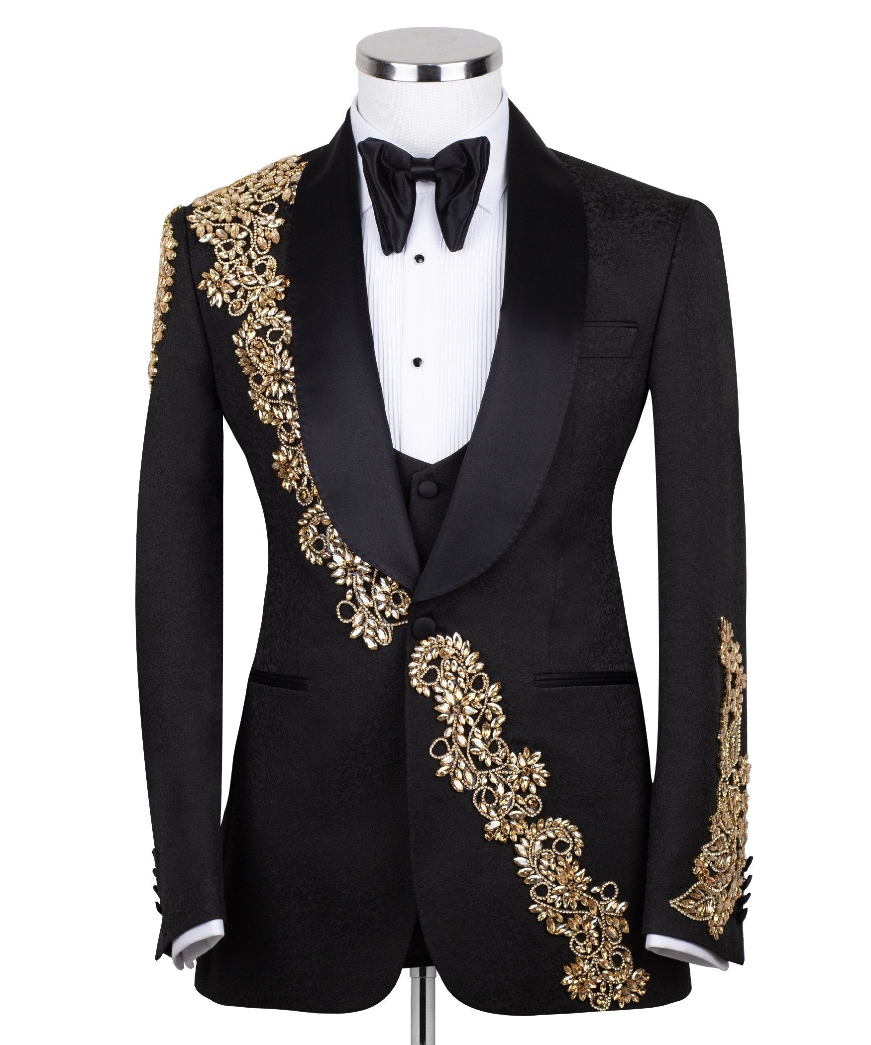 Front view of a black jacquard three-piece tuxedo with intricate gold hand-embellishments on the shawl lapel, shoulder, and cuffs, displayed on a mannequin. From Charly Luxury, handcrafted in Istanbul.