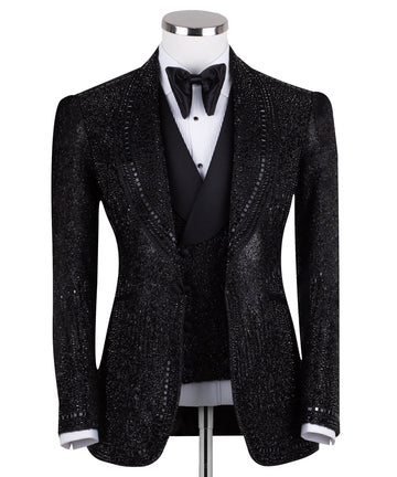 Front view of a black hand-embellished three-piece tuxedo by Charly Luxury, featuring a single-breasted jacket with satin shawl lapels and a double-breasted vest, showcased on a mannequin.