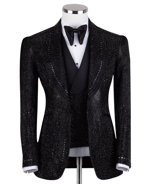 Front view of a black hand-embellished three-piece tuxedo by Charly Luxury, featuring a single-breasted jacket with satin shawl lapels and a double-breasted vest, showcased on a mannequin.