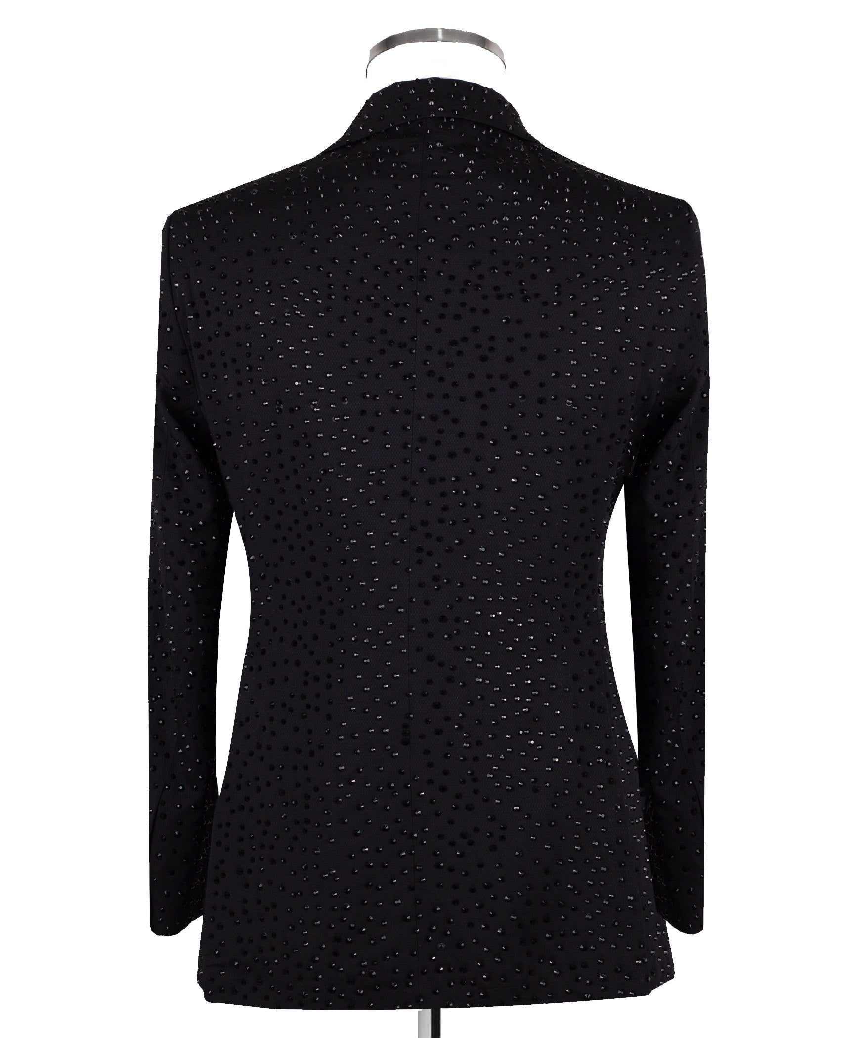 Close-up of a black double-breasted tuxedo jacket on a mannequin, showcasing intricate hand-embellishments with beads and crystals on the lapels and body. Features a peak lapel and black buttons, paired with a white shirt and black bow tie. Front view showing the full jacket and details.