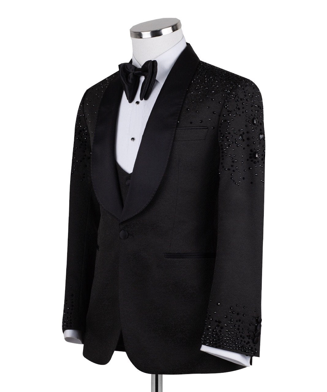 Black hand-embellished three-piece tuxedo by Charly Luxury, featuring an intricate beaded pattern on the shoulders and back, satin shawl lapel, and matching vest and trousers. Masterfully crafted in Istanbul for luxury events.