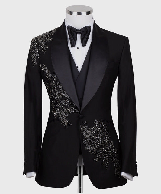 Charly Luxury Black Embellished Three-Piece Tuxedo. Handcrafted single-breasted jacket with peak lapel and shimmering crystal embellishments. Includes matching double-breasted vest and trousers.