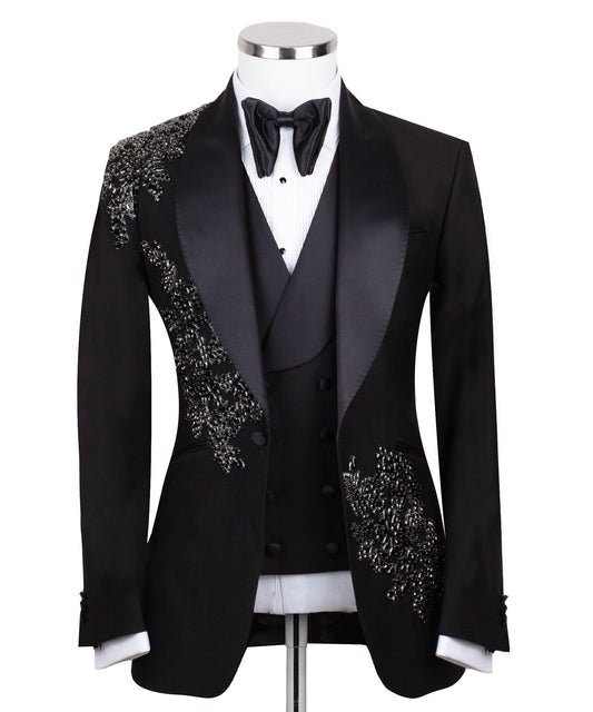 Charly Luxury Black Embellished Three-Piece Tuxedo. Handcrafted single-breasted jacket with peak lapel and shimmering crystal embellishments. Includes matching double-breasted vest and trousers.