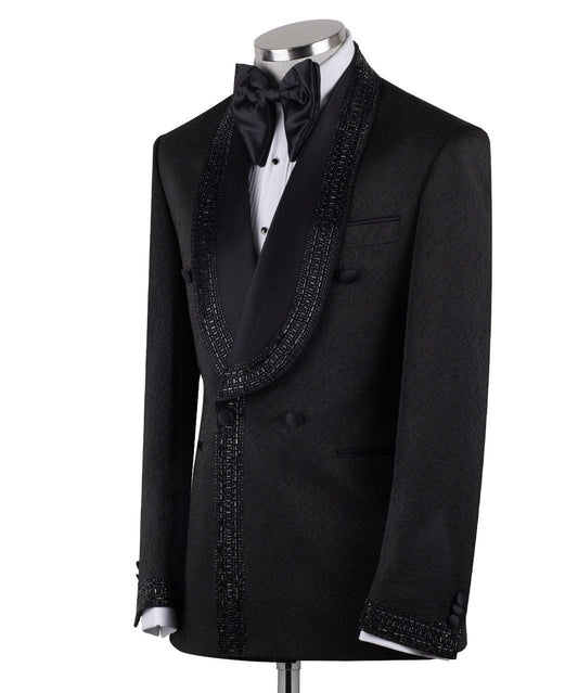 Front view of a black textured double-breasted tuxedo with hand-embellished shawl lapels, cuffs, and front trim. The trousers have a satin side stripe. High-end luxury formal wear from Charly Luxury.