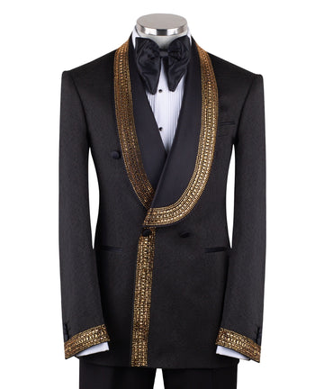 Mannequin wearing a black double-breasted tuxedo with ornate gold beaded peak lapels and matching cuff embellishments, paired with black satin-striped trousers.