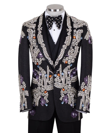 Front and side view of a black tuxedo jacket with extensive silver, purple, orange, and blue crystal and gemstone embellishments in floral and baroque patterns, paired with matching black trousers and vest, on a mannequin. Showcases intricate hand-embellished details and luxurious craftsmanship from Charly Luxury, Istanbul.