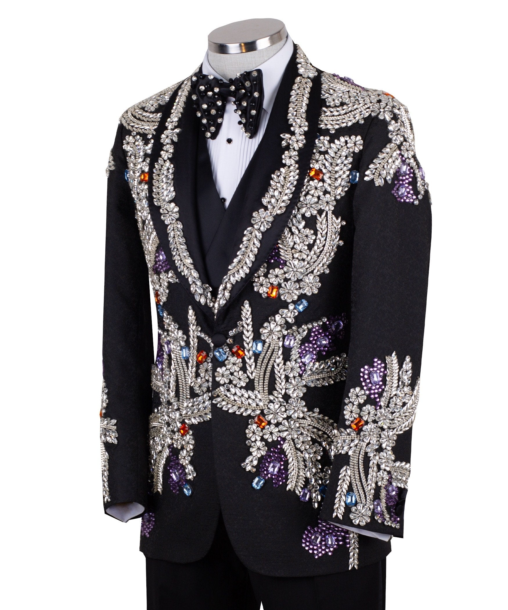 Front and side view of a black tuxedo jacket with extensive silver, purple, orange, and blue crystal and gemstone embellishments in floral and baroque patterns, paired with matching black trousers and vest, on a mannequin. Showcases intricate hand-embellished details and luxurious craftsmanship from Charly Luxury, Istanbul.