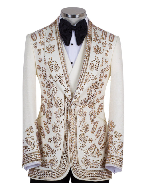 Cream and gold hand-embellished tuxedo jacket, vest, and black trousers from Charly Luxury, handcrafted in Istanbul. Features intricate floral metallic stud detailing on a slim-fit, peak lapel design.