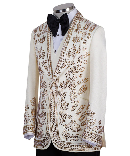 Cream and gold hand-embellished tuxedo jacket, vest, and black trousers from Charly Luxury, handcrafted in Istanbul. Features intricate floral metallic stud detailing on a slim-fit, peak lapel design.