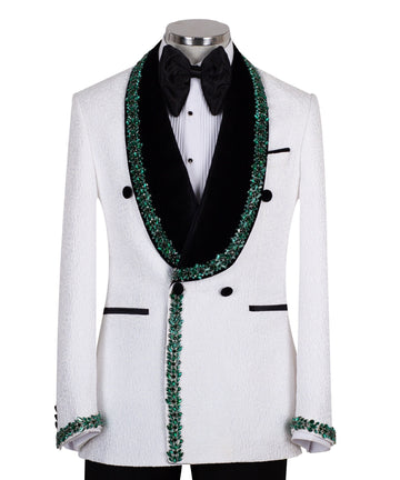 White double-breasted tuxedo jacket with textured fabric, black velvet shawl lapel, emerald green hand-embellished jewels, black buttons, and matching black trousers. Luxurious, handcrafted in Istanbul by Charly Luxury.