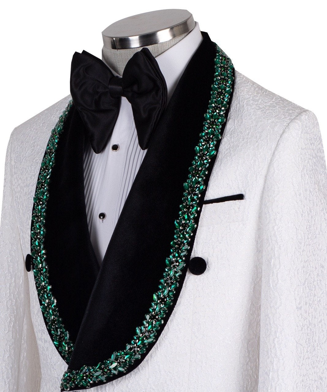 White double-breasted tuxedo jacket with textured fabric, black velvet shawl lapel, emerald green hand-embellished jewels, black buttons, and matching black trousers. Luxurious, handcrafted in Istanbul by Charly Luxury.
