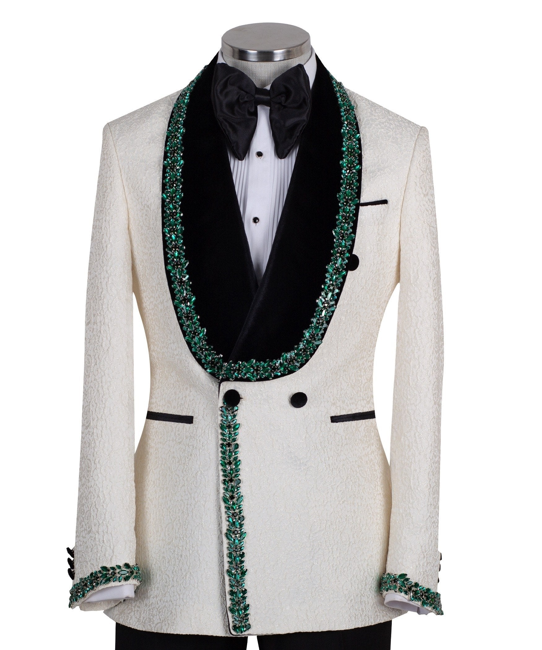 Charly Luxury Cream textured double-breasted tuxedo with black velvet shawl lapel and emerald green hand-embellishments on jacket front, lapel, and cuffs, paired with black trousers.