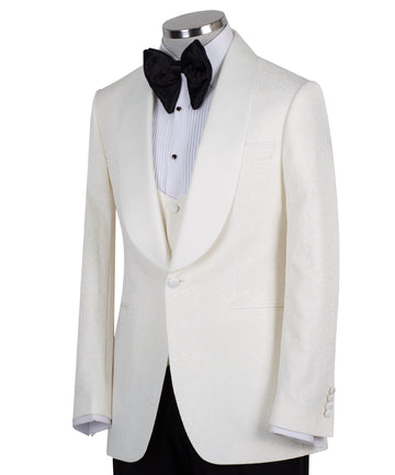 Front view of an ivory jacquard three-piece tuxedo with black trousers on a mannequin. Features a single-breasted jacket with a satin shawl lapel, matching U-neck vest, and subtle floral pattern. Ideal for weddings and formal events.